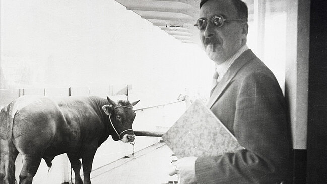 Plakat zur Sonderausstellung Stefan Zweig. Weltautor. Zu sehen ist Stefan Zweig auf einer schwarz/weiß Aufnahme mit Sonnenbrillen, neben ihm ein Stier.